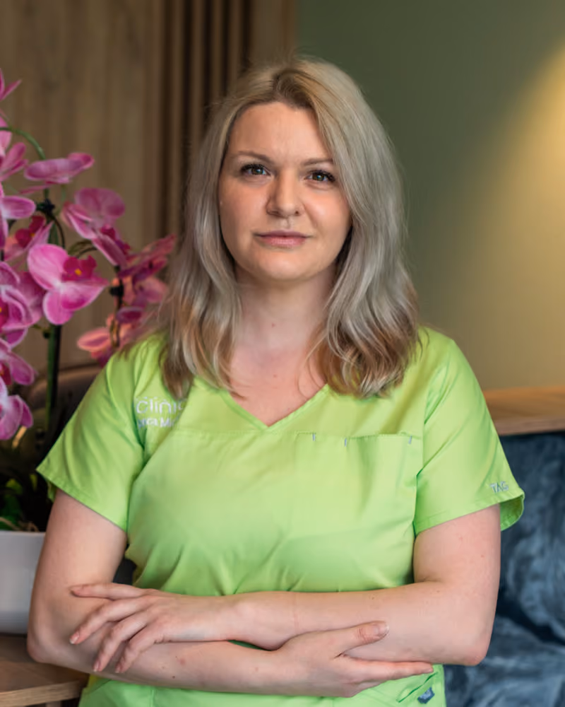 Dr. Anca Miclăuș, medic specialist chirurgie generală, în halat verde A Clinic, la recepția clinicii