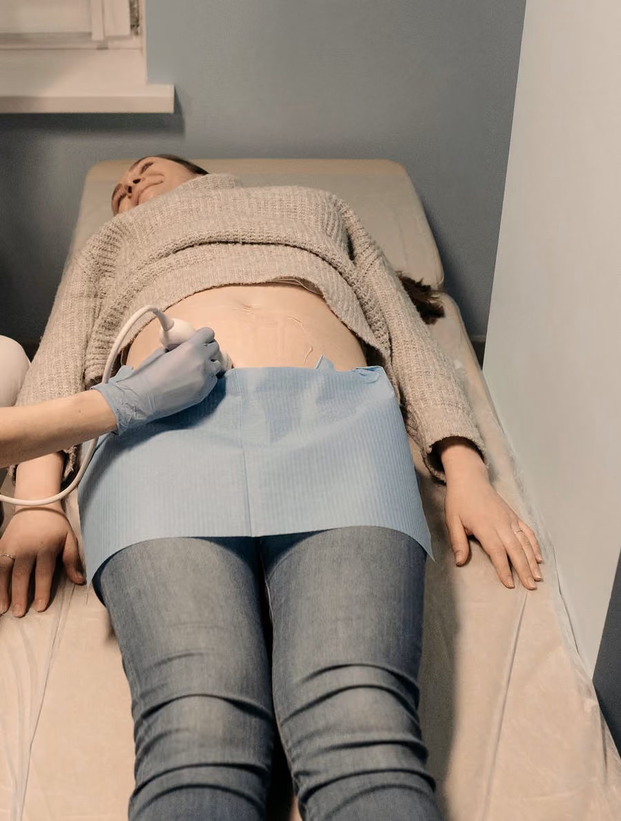 Examinare ecografică abdominală: pacienta stă întinsă pe patul de examinare, iar transductorul este aplicat pe abdomen